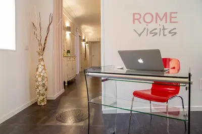 a glass table with a laptop on a red chair at Rome Visits in Rome