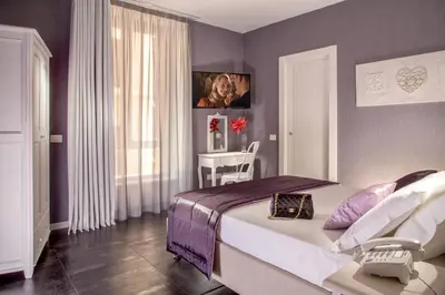a bedroom with a bed and a table with a chair at Rome Visits in Rome