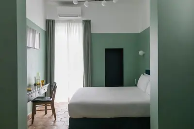 a bedroom with a bed and a desk and a window at UnoUnOtto in Rome
