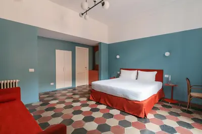 a bedroom with a bed and a red chair at UnoUnOtto in Rome