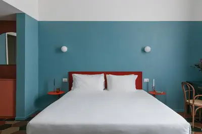 a bedroom with a large bed with a blue wall at UnoUnOtto in Rome