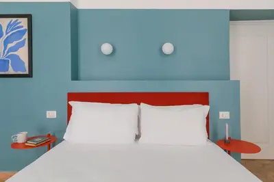a bedroom with a bed with a blue headboard at UnoUnOtto in Rome