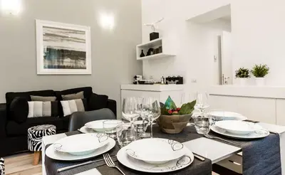 a dining room with a table with plates and wine glasses at Thebestinrome Piazza di Spagna in Rome