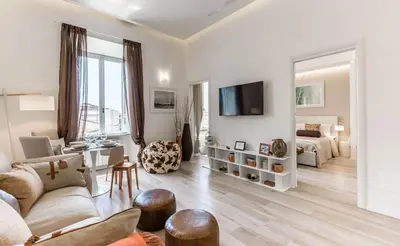 a white living room with a couch and a tv at Thebestinrome Piazza di Spagna in Rome