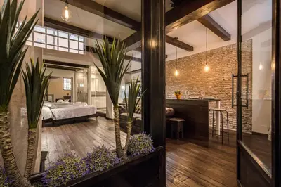 a room with plants and a bedroom in the background at Trinità dei Monti Suite in Rome
