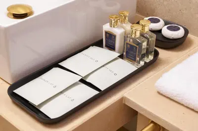 a tray with bottles of soap and towels on a table at Borghese Contemporary Hotel in Rome