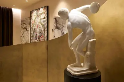a statue of a boy playing a ball in a museum at Borghese Contemporary Hotel in Rome