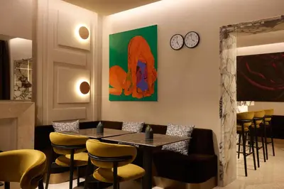 a restaurant with a table and chairs and a clock at Borghese Contemporary Hotel in Rome