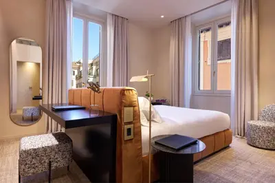 a bedroom with a bed and a desk and a mirror at Borghese Contemporary Hotel in Rome