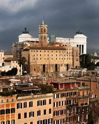 an old building with a clock tower in a city at La Cupola del Vaticano in Rome
