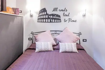 a bedroom with a bed with pink sheets and pillows at Del Falco Boutique Rooms San Pietro in Rome