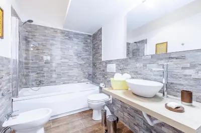 a bathroom with a sink and a tub and a toilet at Del Falco Boutique Rooms San Pietro in Rome