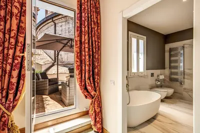a bathroom with a tub and a large window at Eitch Borromini Palazzo Pamphilj in Rome