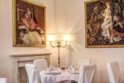 a dining room with a table and a painting on the wall at Eitch Borromini Palazzo Pamphilj in Rome