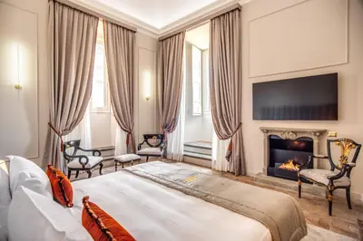 a bedroom with a bed and a fireplace at Eitch Borromini Palazzo Pamphilj in Rome