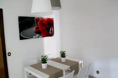 a dining room with a table and a red flower on the wall at Nonna grazia in Rome