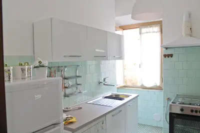 a kitchen with white cabinets and a white refrigerator at Nonna grazia in Rome