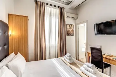 a bedroom with a bed and a desk with a computer at Magenta Deluxe Cancello in Rome