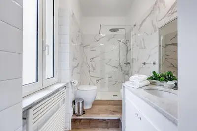 a white bathroom with a sink and a shower at Living Rome Repubblica apartment in Rome