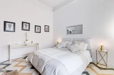 a white bedroom with a white bed and a table at Living Rome Repubblica apartment in Rome
