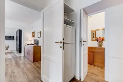 a kitchen with white walls and a hallway with a refrigerator at Living Rome Repubblica apartment in Rome