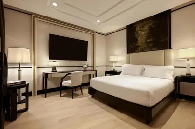 a bedroom with a bed and a desk and a television at Nobu Hotel Roma in Rome