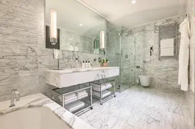 a bathroom with a tub and a sink and a shower at Nobu Hotel Roma in Rome