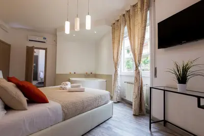 a bedroom with a bed and a television and a tub at Luxury House Vaticano in Rome