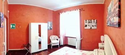 a bedroom with orange walls and a bed and a mirror at CiaoRoma! in Rome