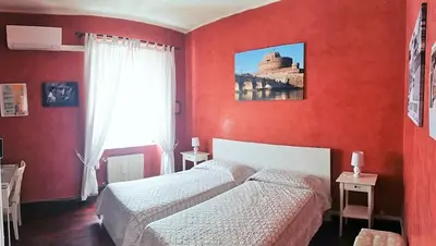 two beds in a room with red walls at CiaoRoma! in Rome