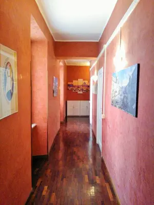 a hallway with orange walls and wooden floors and a hallway sidx sidx at CiaoRoma! in Rome