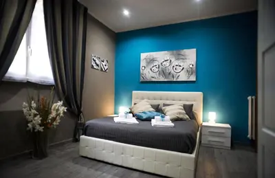 a bedroom with a bed with a blue wall at Costantino Secondo Guest House in Rome