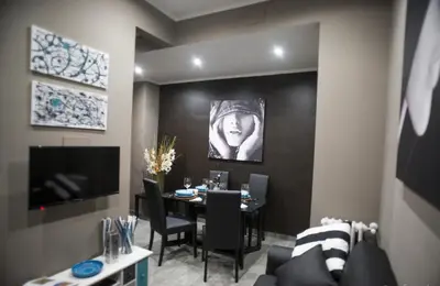a dining room with a table and a tv at Costantino Secondo Guest House in Rome