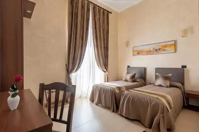 a bedroom with two beds and a table and a window at New Joyful Guest House in Rome