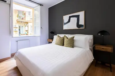 a bedroom with a large white bed and a window at Maison Boncompagni in Rome