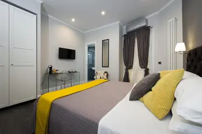 a bedroom with a large bed with a yellow blanket at Maison Boncompagni in Rome