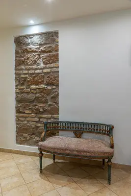 a bench sitting in front of a stone wall at Camere del Camerlengo in Rome