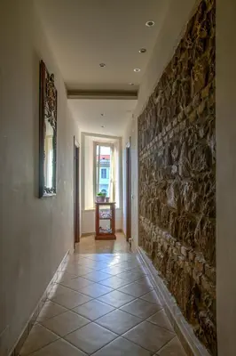a hallway with a stone wall and a tile floor at Camere del Camerlengo in Rome