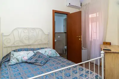 a bedroom with a bed with a blue comforter at Camere del Camerlengo in Rome