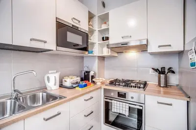 a kitchen with white cabinets and a sink and a stove at Vaticanum Modern & Family Apartment in Rome