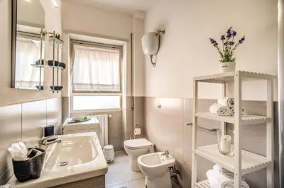 a white bathroom with a sink and a toilet at Vaticanum Modern & Family Apartment in Rome