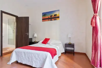 a bedroom with a bed with a red blanket at Roma Enrico Guesthouse in Rome