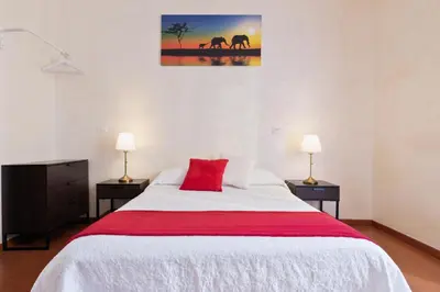 a bedroom with a large white bed with a red pillow at Roma Enrico Guesthouse in Rome