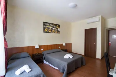 a hotel room with two beds with towels on them at Roma Enrico Guesthouse in Rome