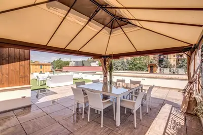 a patio with a table and chairs and an umbrella at The Bricks Rome in Rome