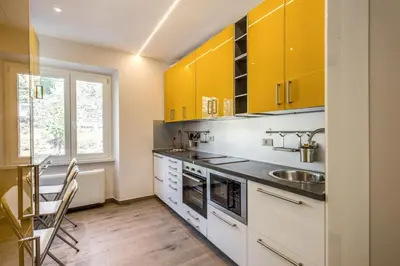 a kitchen with yellow cabinets and a sink at The Bricks Rome in Rome