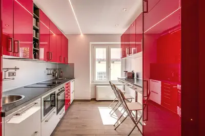 a red kitchen with red cabinets and a sink at The Bricks Rome in Rome