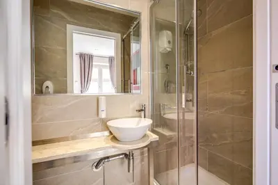 a bathroom with a sink and a glass shower at The Bricks Rome in Rome