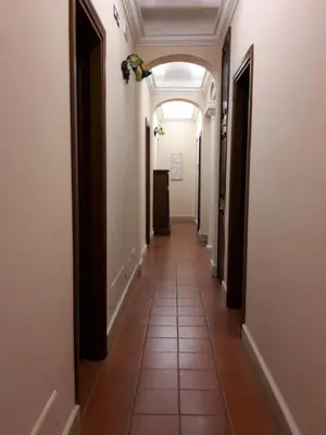a hallway of a building with an archway at Hotel 4 Coronati in Rome