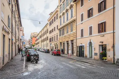 a city street with cars parked on a cobblestone street at Hotel 4 Coronati in Rome